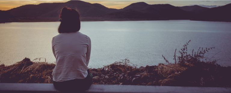 woman looking at view of lake and mountains