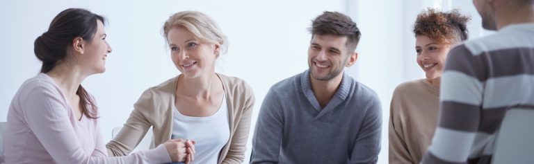 A group of people sitting in circle participating in rehab for alcohol abuse.