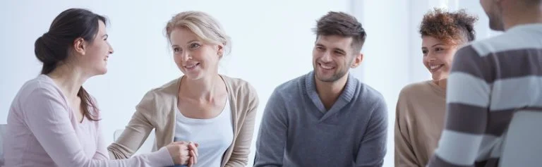A group of people sitting in circle participating in rehab for alcohol abuse.