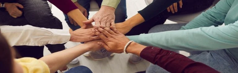 group of people with their hands in a circle