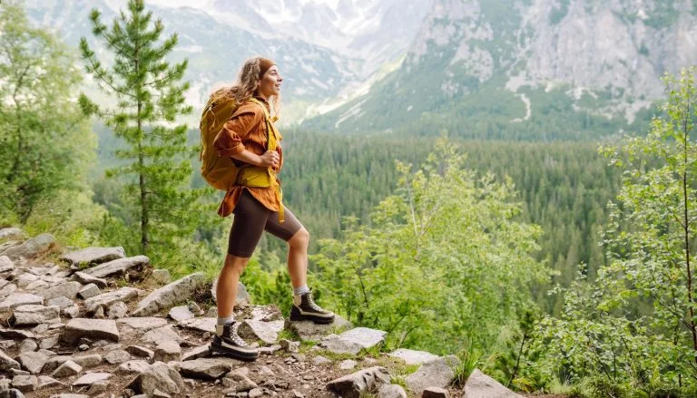 Young woman hiking in the summertime in Asheville, NC, managing summer depression in recovery.