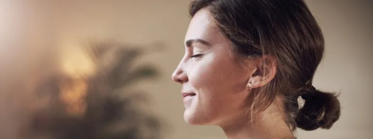 Woman meditating for mental health, depicting taking care of your mental health around holidays.