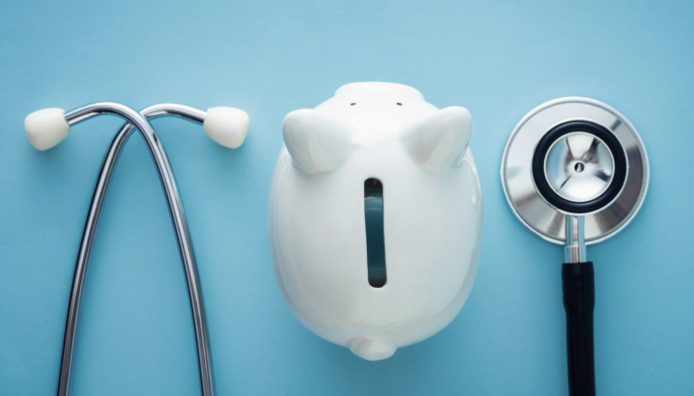 Stethoscope and piggy bank on a blue background. Symbolizing addiction treatment costs in Asheville, NC.