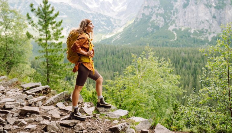 Young woman hiking in the summertime in Asheville, NC, managing summer depression in recovery.