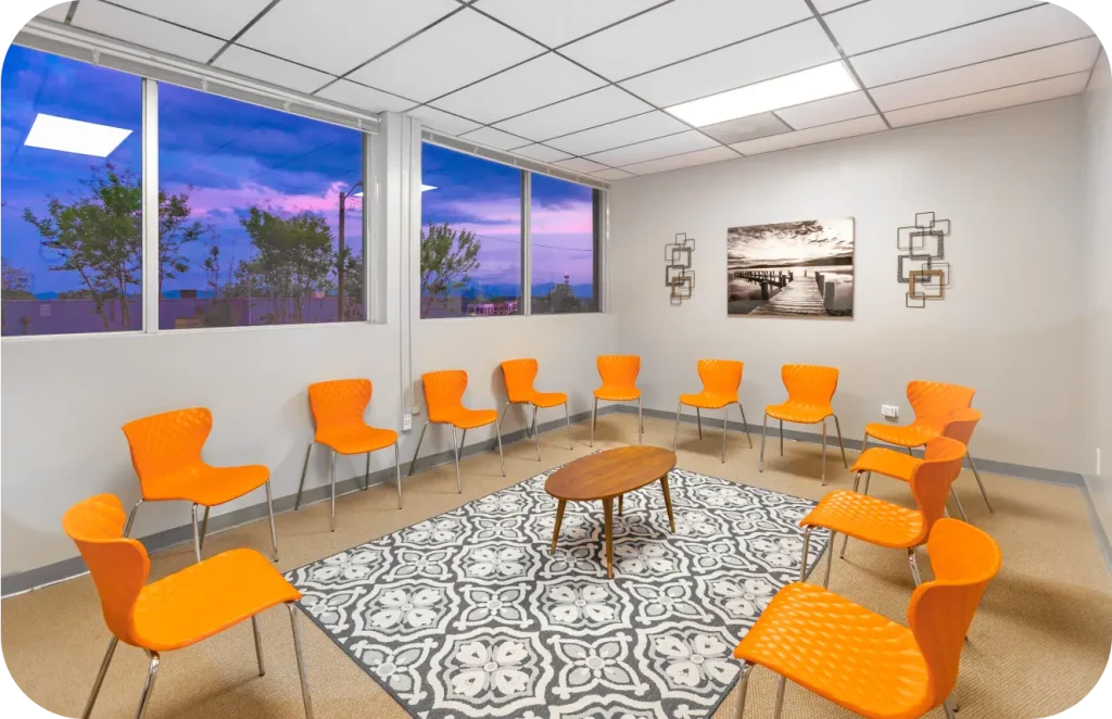 group room with orange chairs arranged in a circle at night