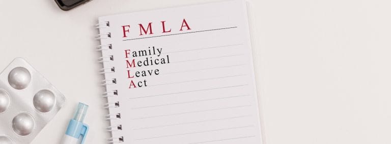 A note pad with the words Family Medical Leave Act (FMLA) written on it.