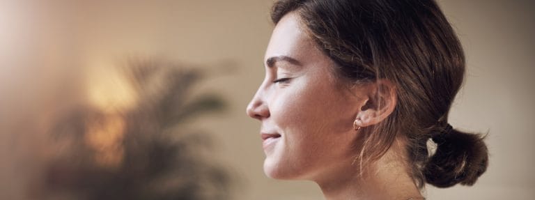 Woman meditating for mental health, depicting taking care of your mental health around holidays.